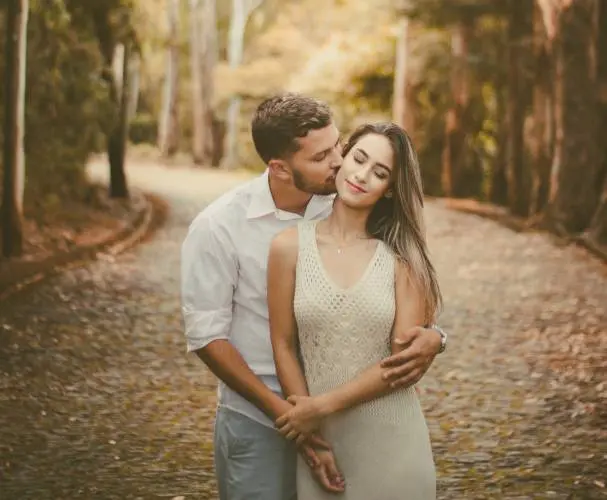 a man kissing a woman on the cheek from the back.